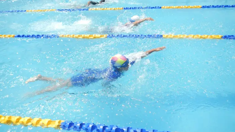 A student swimming freestyle in the school pool at DPS Chhindwara